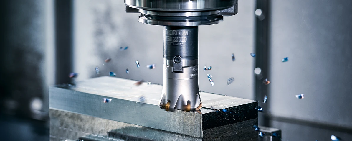 A Spinworx milling cutter from Pokolm in action. A metal block is being milled, the chips are flying.