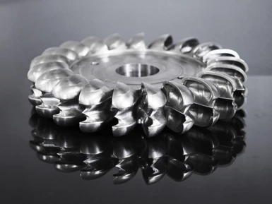 A milled Pelton wheel lying on a dark background