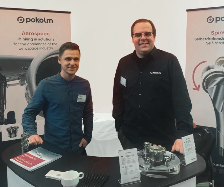 Mitarbeiter der Firma Pokolm stehen auf dem Pokolm-Messestand einer Veranstaltung.